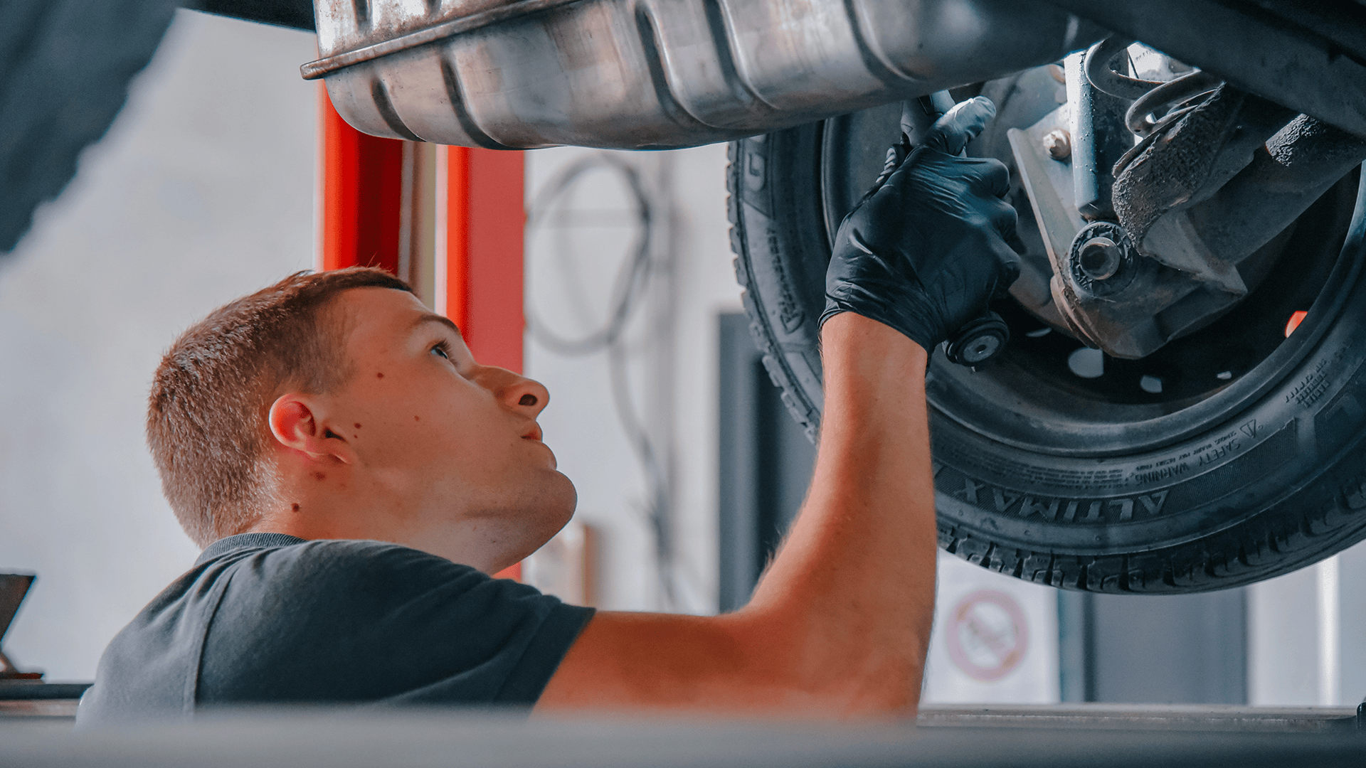Contrôle du châssis en atelier Mécanicien effectuant une opération sous le châssis d’un véhicule