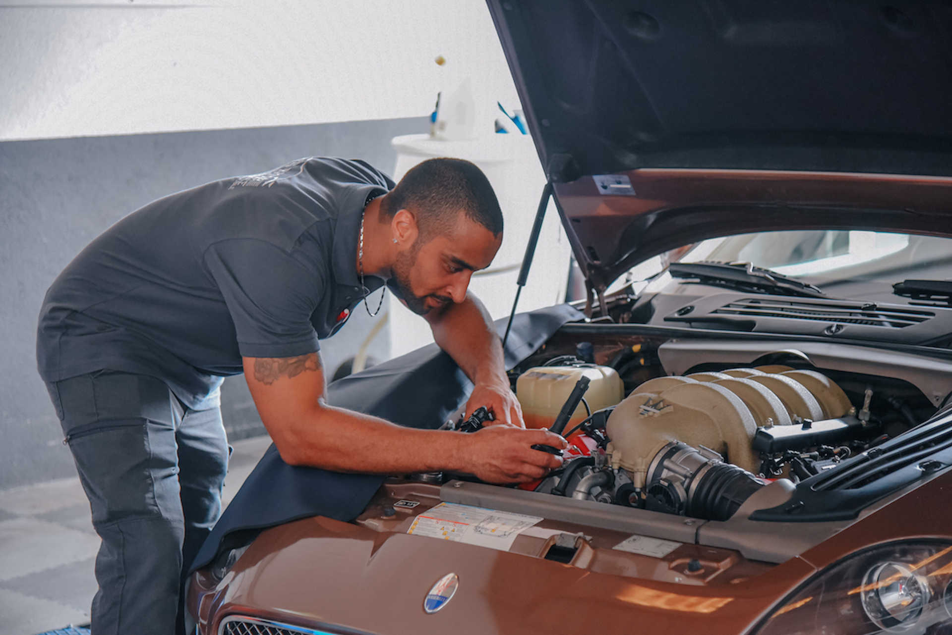 Entretien moteur sur véhicule Mécanicien travaillant sur le moteur d’une voiture avec le capot ouvert